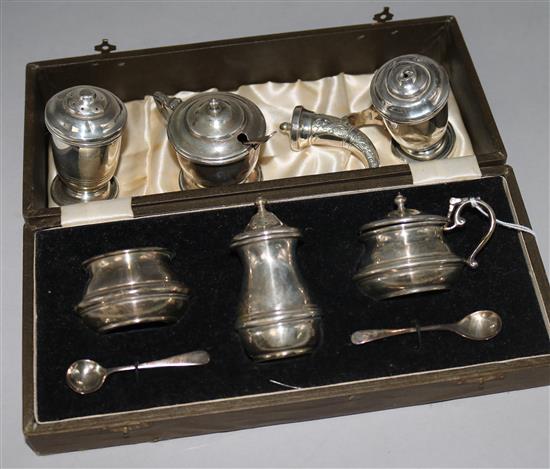 A cased silver cruet set and four other silver cruets.